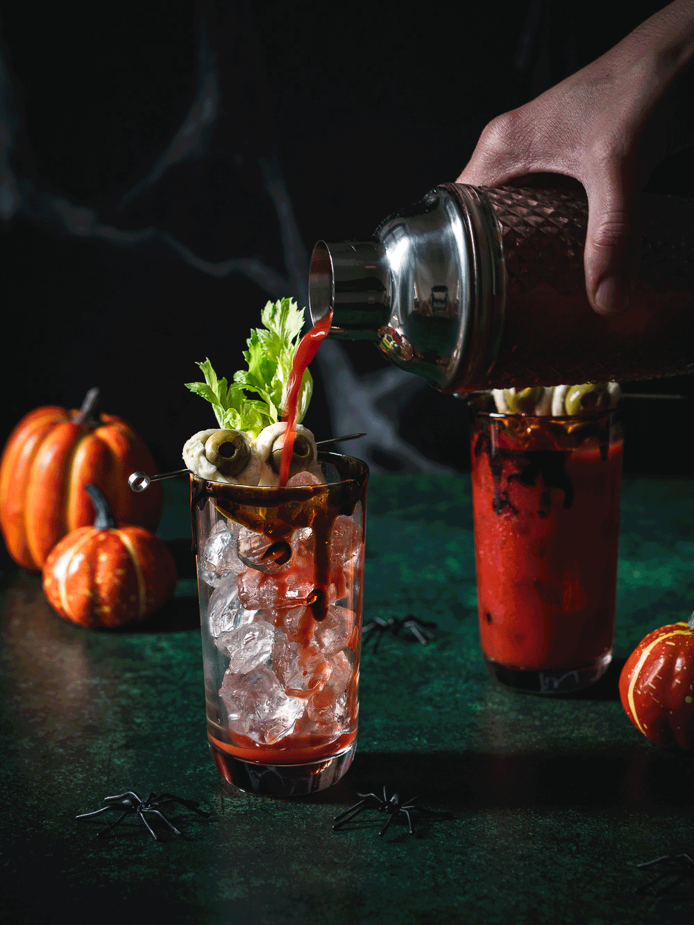 Gif von Zwei Bloddy Mary Cocktails mit gruseligen Olivenaugen und Halloweendeko.