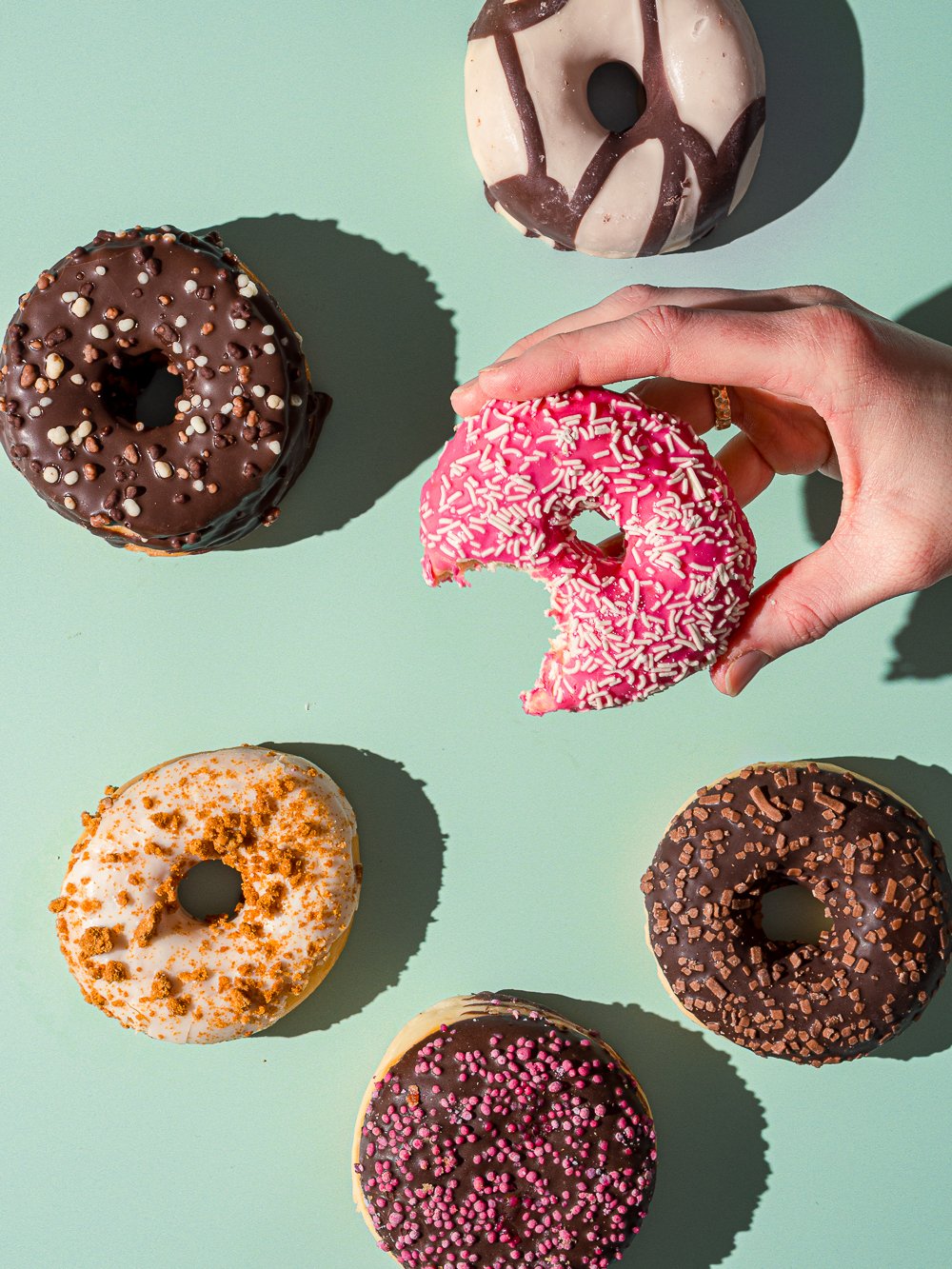 Bunte Dontus auf einem gr&uuml;nen Untergrund,einer ist angebissen